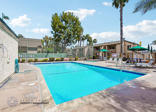 A pool with a blue tinted water and a logo of Beach Front Property Management on the side.