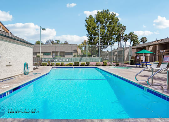A swimming pool with a blue tiled edge and a white wall on the left.