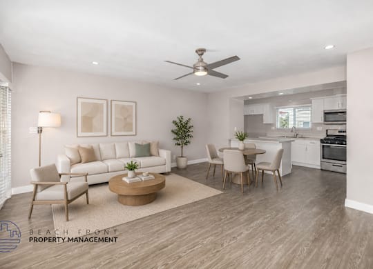 A living room with a white couch, a coffee table, and a dining table with chairs.