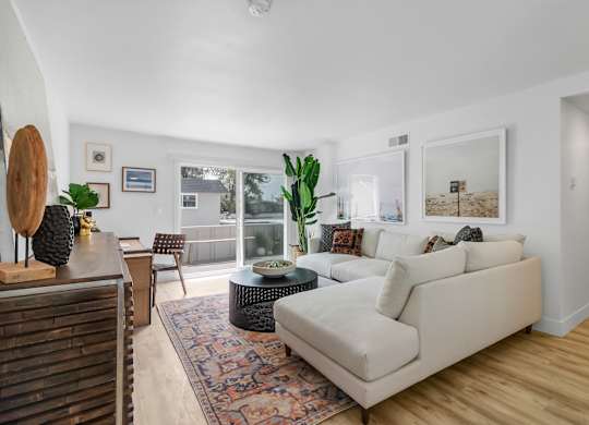 A living room with a white couch and a rug.
