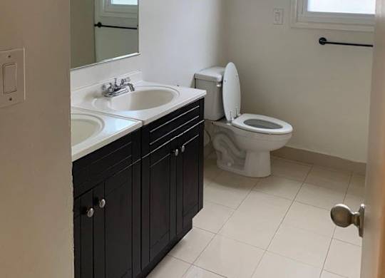 A bathroom with a sink, mirror, and a sign that says