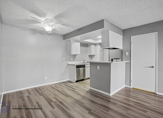 A kitchen area with a refrigerator, oven, and cabinets.