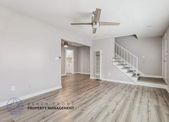 A spacious room with a staircase leading to another room.