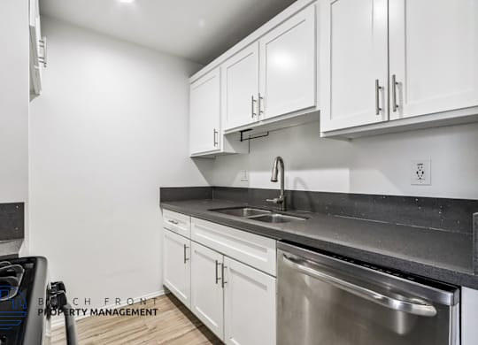 A modern kitchen with white cabinets and stainless steel appliances.
