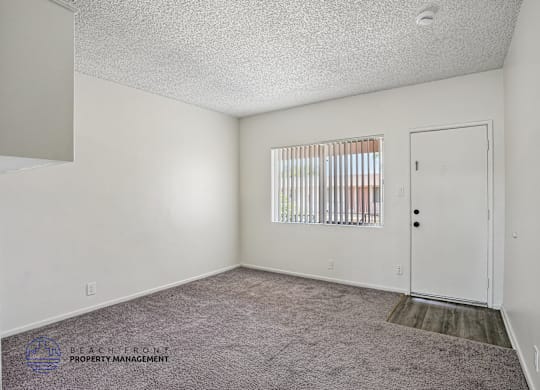 A room with a carpeted floor and a door.