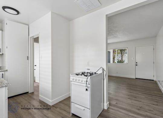 A white kitchen with a stove and a refrigerator.