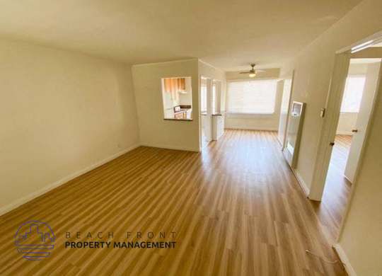 a empty living room and hallway with wood floors
