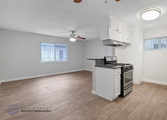 A kitchen with a stove top oven and a fan on the ceiling.