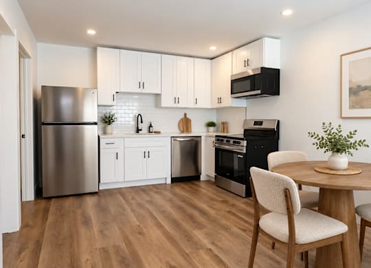 A modern kitchen with wooden floors and stainless steel appliances.