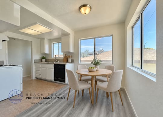 A dining room with a table set for four and a view of the beach.