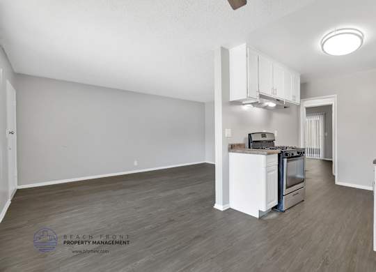 A spacious kitchen with white cabinets and a stainless steel stove.