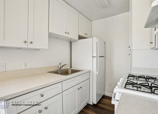 A kitchen with white cabinets and a white stove top.