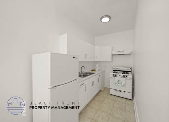 A kitchen with white appliances and cabinets, with a logo for Beach Front Property Management in the bottom left corner.