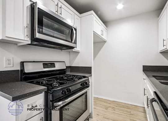 A kitchen with a stove, microwave, and oven.