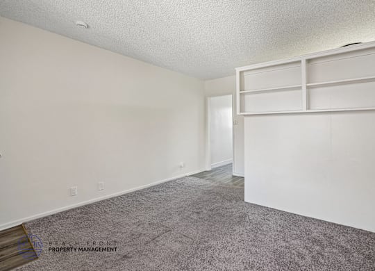A room with a grey carpet and white walls.