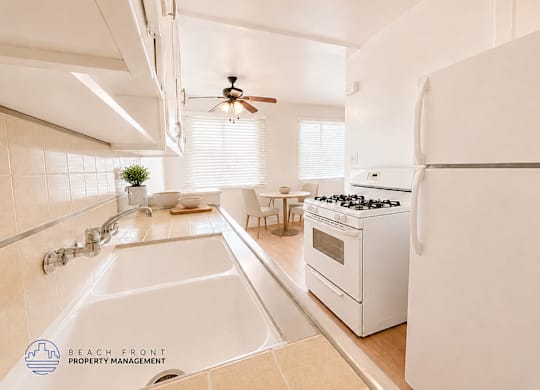 A white kitchen with a sink and a stove.