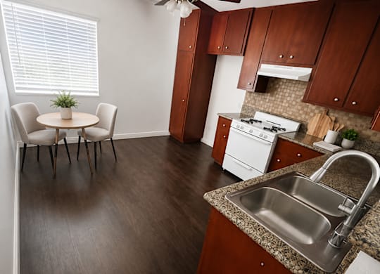 A kitchen with a table and chairs in front of a window.