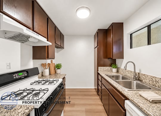 A kitchen with a stove top oven and a sink.