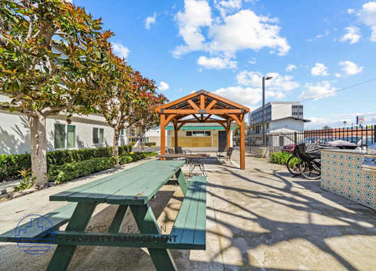 a picnic area with benches and a wooden pavilion