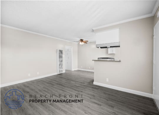 a living room with a kitchen and a ceiling fan