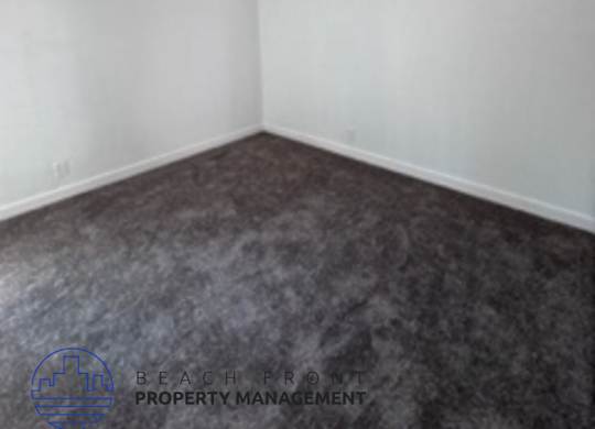 A room with a white wall and a grey floor.