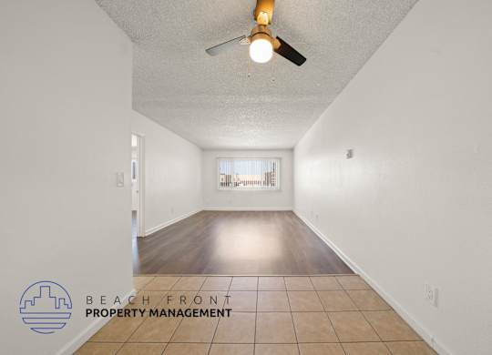 A room with a ceiling fan and tiled floor.