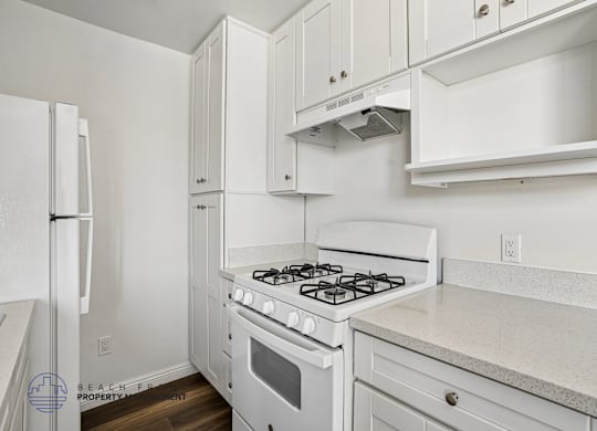 A white kitchen with a stove and cabinets.