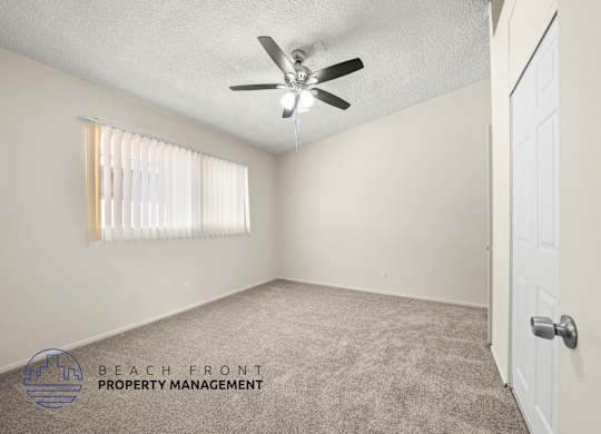 A room with a ceiling fan and a closed door.