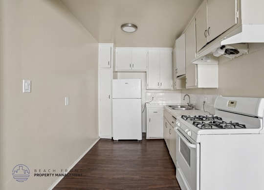 A kitchen with white appliances and cabinets.