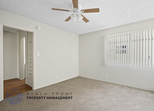 A room with a ceiling fan and a radiator on the wall.