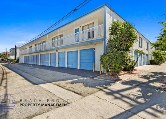 A building with a blue door is managed by Beach Front Property Management.