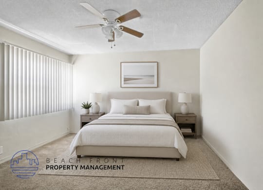 A bedroom with a bed, nightstands, and a ceiling fan.