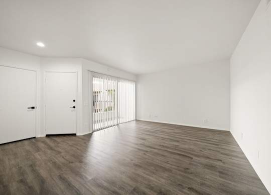 A room with wooden flooring and white walls.