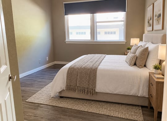 A bedroom with a large bed and a window.