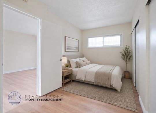 A bedroom with a bed, nightstand, and a plant.