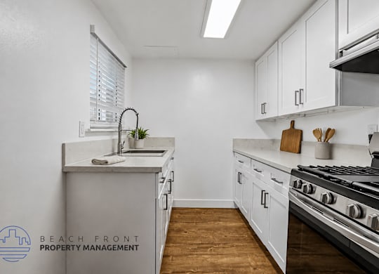 A kitchen with white cabinets and a stainless steel stove.