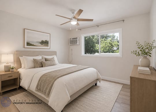 A bedroom with a bed, nightstand, and a painting on the wall.