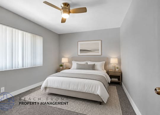 A well-lit bedroom with a large bed and a ceiling fan.