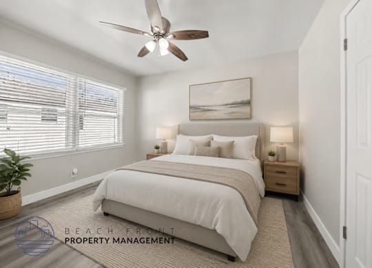 A well-lit bedroom with a large bed and a ceiling fan.