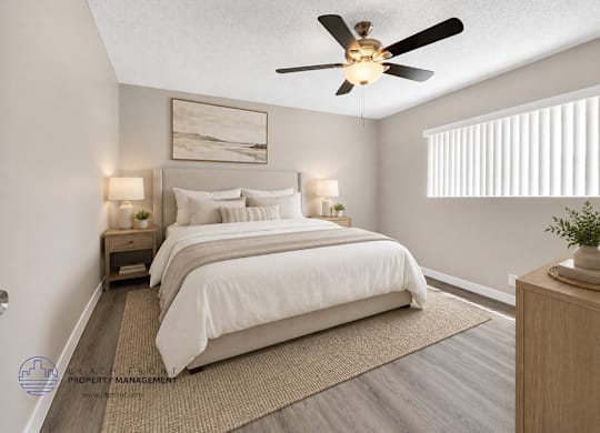 A bedroom with a large bed and a ceiling fan.