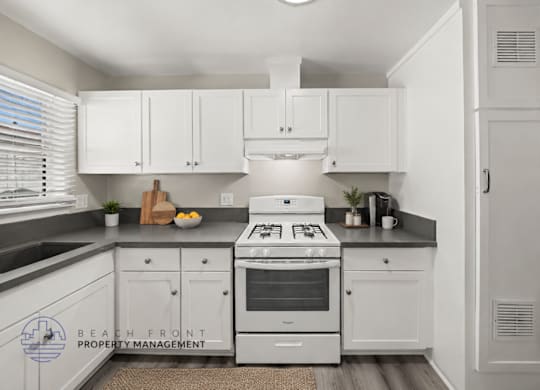 A kitchen with white cabinets and a stove top oven.