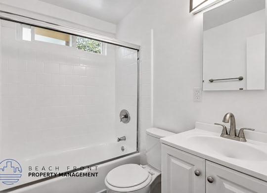A white bathroom with a toilet, sink, and tub.