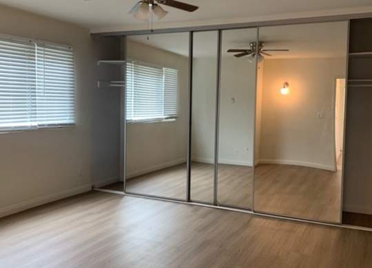 A white room with a wooden floor and a white ceiling.