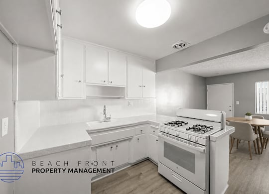 A kitchen with white cabinets and a stove top oven.