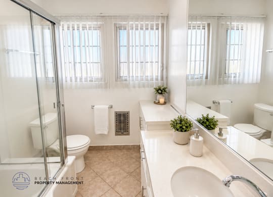 A bathroom with a toilet, sink, and mirror.