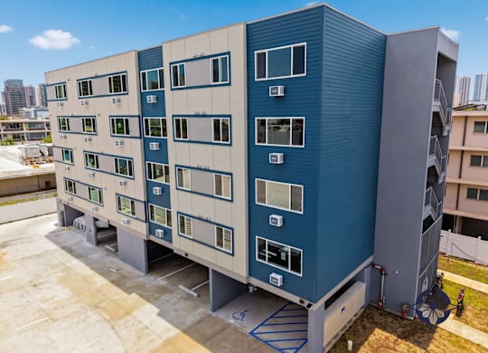 A blue and white building with many windows and air conditioning units.