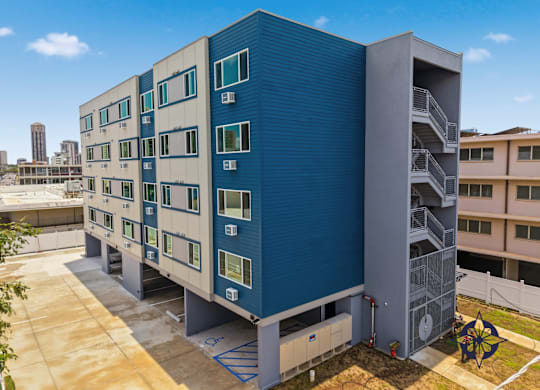 A blue and white building with a metal staircase on the side.