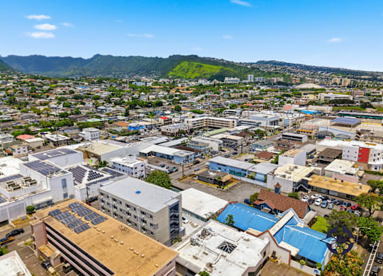 A cityscape with buildings and solar panels on the roofs.