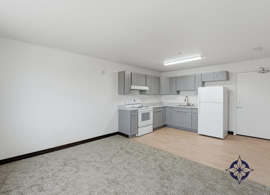 A kitchen with white appliances and a grey backsplash.