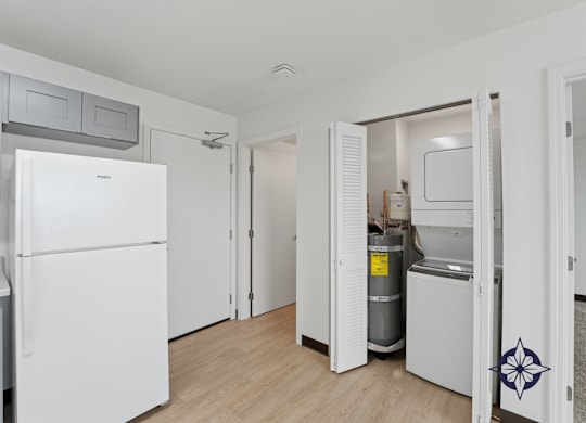 A white refrigerator is in a kitchen with a white door.